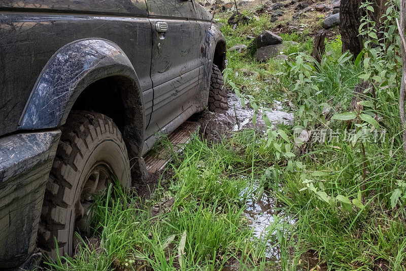 越野车陷在泥里了。沼泽里肮脏的越野车。探险旅游的概念。4 × 4越野车陷入泥潭。旅行,旅游的概念。